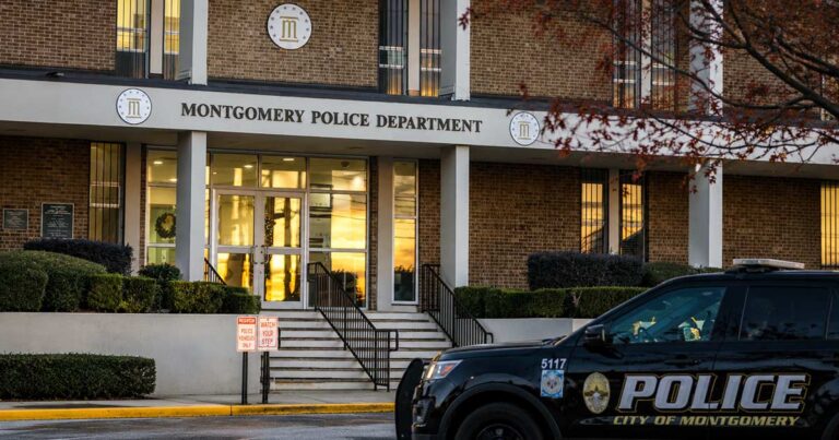 Montgomery Police Department headquarters at dusk, with a marked police SUV parked in front of the building's main entrance.
